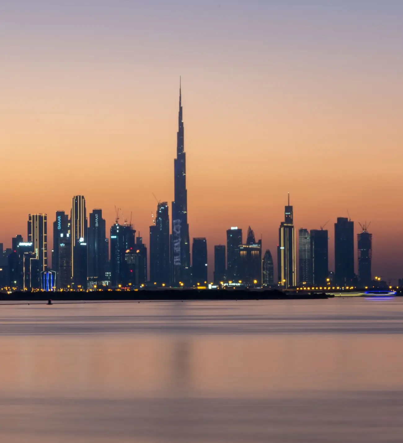 Skyline de Downtown Dubaï et Burj Khalifa au coucher du soleil, vus depuis l'eau